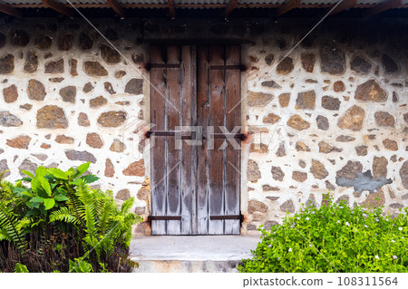 Old brown wooden door in a stone wall, front view, background 108311564