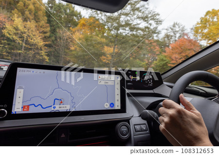 在秋季道路上行駛的汽車的駕駛座 在秋季道路上行駛的汽車的駕駛座 108312653