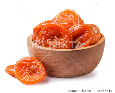 Dried apricots in a wooden plate and scattered on a white background. Isolated Dried apricots in a wooden plate and scattered on a white background. Isolated 108313614