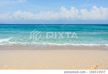Sandy beach with rolling calm wave of ocean on sunny day on background white clouds in blue sky 108313937