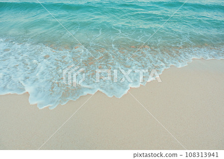 Soft wave of blue ocean on sandy beach. Summer vacation in island. clear azure water Background. Soft wave of blue ocean on sandy beach. Summer vacation in island. clear azure water Background. 108313941