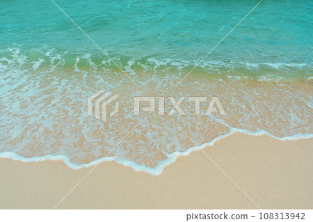 Soft wave of blue ocean on sandy beach. Summer vacation in island. clear azure water Background. 108313942