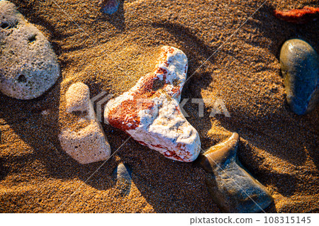 sea sand and stones on the beach at sunset sea sand and stones on the beach at sunset 108315145