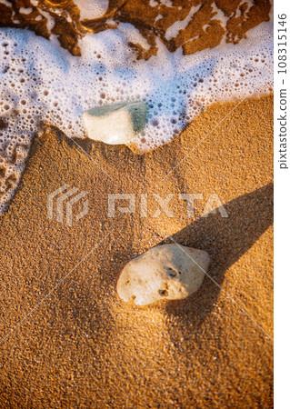 sea sand and stones, waves on the beach at sunset sea sand and stones, waves on the beach at sunset 108315146