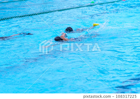 child swimmer swim in swimming pool. Water sports training and competition, learning to swim classes for children child swimmer swim in swimming pool. Water sports training and competition, learning to swim classes for children 108317225