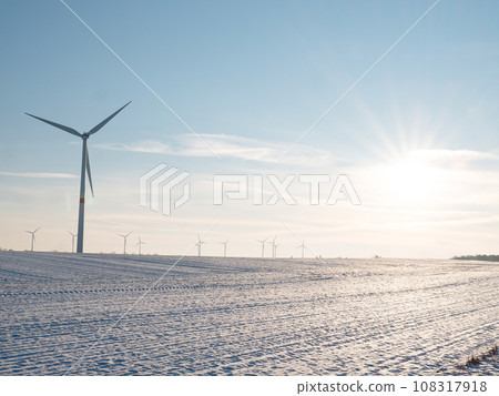 Wind turbines and agricultural field on winter day. 108317918