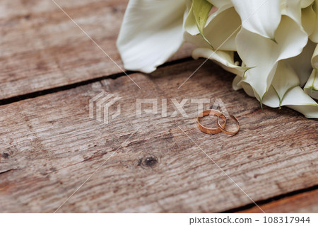 A wedding bouquet of white flowers lies on old wooden boards. A wedding bouquet of white flowers lies on old wooden boards. 108317944