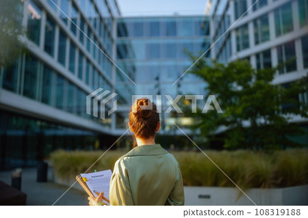 Seen from behind business woman near office building 108319188
