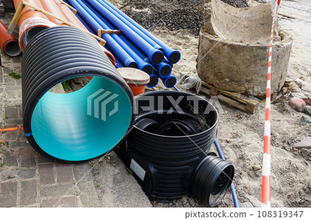 Replacement of water supply and sewer pipes, dirty old pipes next to new modern plastic pipes Replacement of water supply and sewer pipes, dirty old pipes next to new modern plastic pipes 108319347
