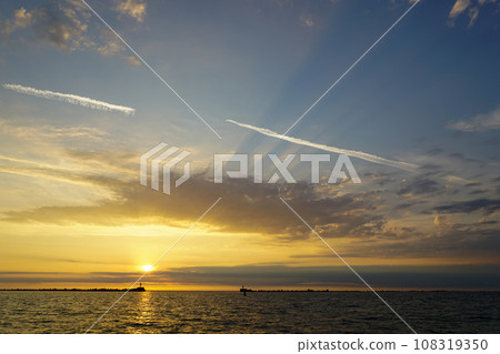A beautiful multicolor golden sunset on the shore of the Baltic Sea, golden sunset on the seashore A beautiful multicolor golden sunset on the shore of the Baltic Sea, golden sunset on the seashore 108319350