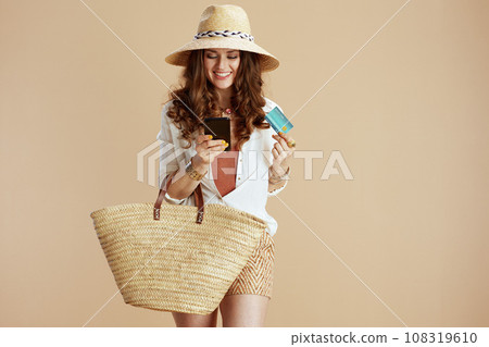 smiling trendy woman in blouse and shorts isolated on beige smiling trendy woman in blouse and shorts isolated on beige 108319610