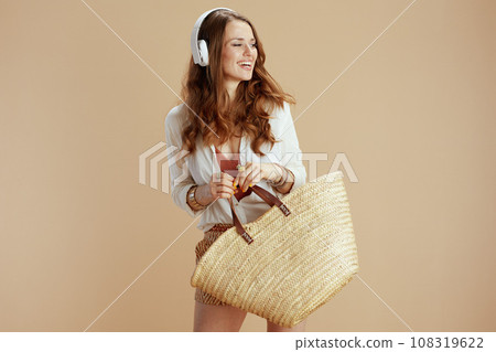 smiling elegant woman in blouse and shorts on beige 108319622