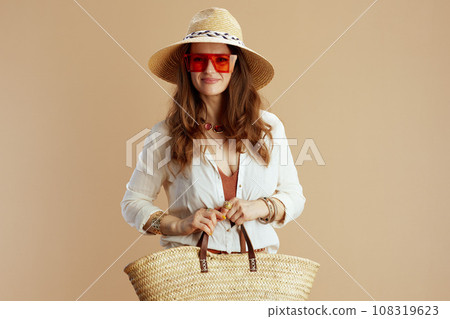 smiling stylish woman in blouse and shorts on beige 108319623