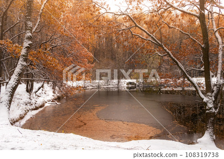 first snow on pond in fall. Picturesque landscape. beginning of winter. Interseason first snow on pond in fall. Picturesque landscape. beginning of winter. Interseason 108319738