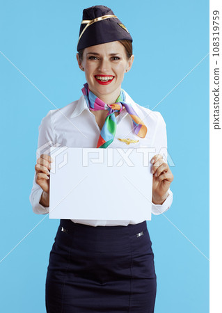happy air hostess woman on blue showing blank a4 paper sheet 108319759
