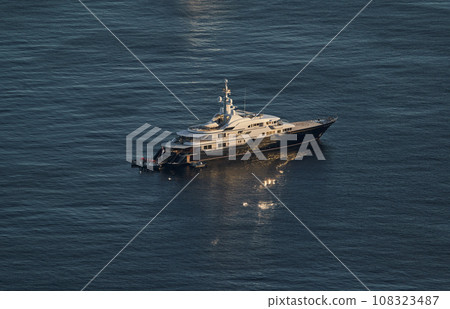 Monaco, lonely mega yacht in sea at sunset, huge motor boat, wealth life of billionaires  108323487