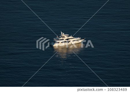 Monaco, lonely mega yacht in sea at sunset, huge motor boat, wealth life of billionaires  108323489
