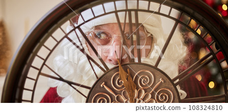 Five minutes to New year or Christmas midnight. Happy Santa Claus shows on the clock Five minutes to New year or Christmas midnight. Happy Santa Claus shows on the clock 108324810