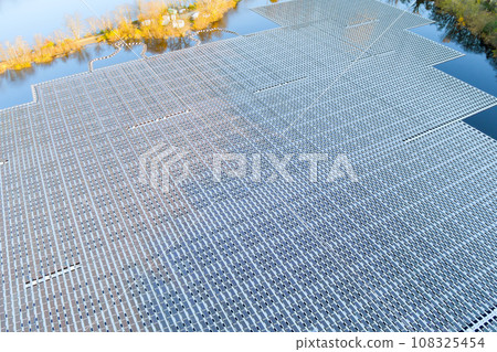 There are floating solar panels in large water pond that are used to generate electricity from suns rays 108325454