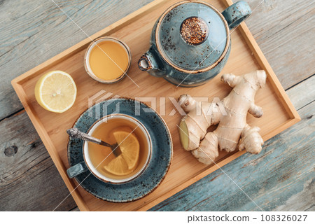 Ginger tea with lemon and honey in a blue cup on a bamboo tray 108326027