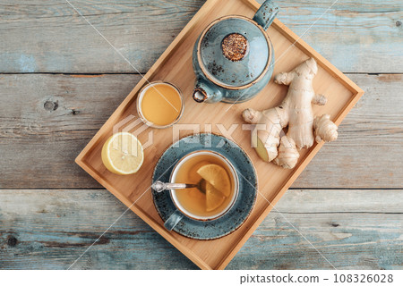Ginger tea with lemon and honey in a blue cup on a bamboo tray Ginger tea with lemon and honey in a blue cup on a bamboo tray 108326028