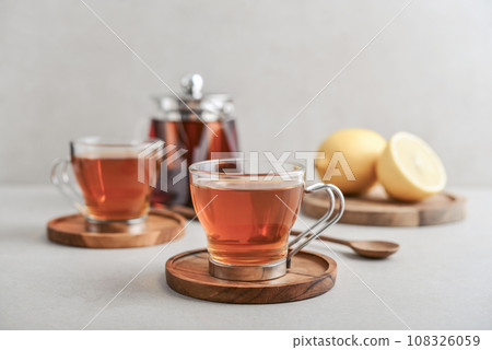 Tea in a glass cups with lemon on cutting board Tea in a glass cups with lemon on cutting board 108326059