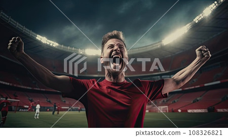 Happy man raising his hands in the air at a football game 108326821