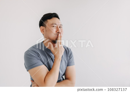 Evil looks of man in blue t-shirt smile and smirk stand isolated on white. 108327137