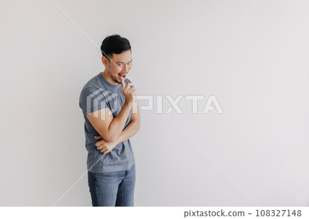 Evil looks of man in blue t-shirt smile and smirk stand isolated on white. Evil looks of man in blue t-shirt smile and smirk stand isolated on white. 108327148