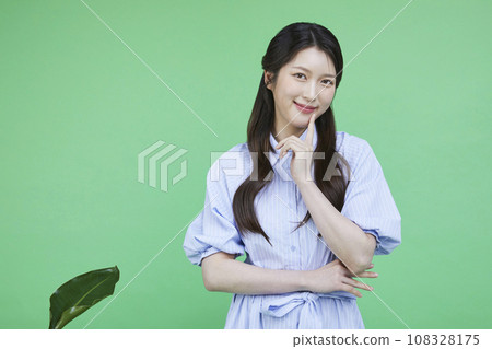 Green consumer_photo image of a korean asain beautiful woman smiling with her finger to her mouth 108328175