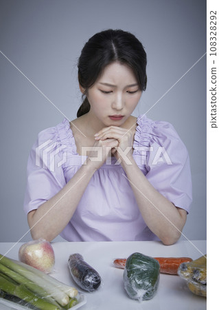 Plastic packaging_Picture image of a korean asain beautiful woman contemplating looking at plastic wrapped vegetables and vegetables fruits 108328292