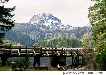 Wooden footbridge over stream and Black Lake. Durmitor National Park, Montenegro 108328784