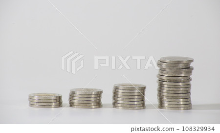 Men's hands stacking growing piles of silver coins Money concept and saving money Men's hands stacking growing piles of silver coins Money concept and saving money 108329934