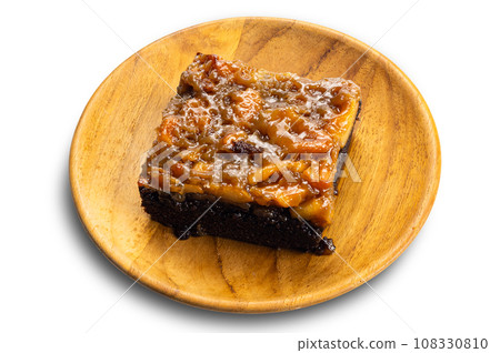 View of delicious homemade chocolate toffee cake topping with cashew nut and caramel in wooden plate. 108330810