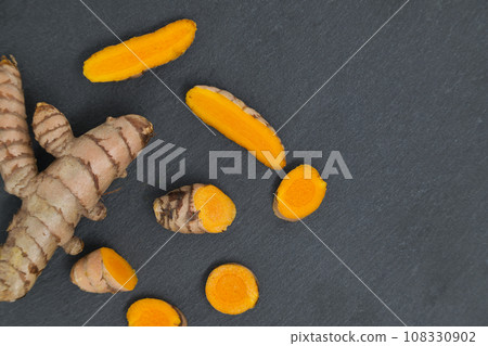 Fresh turmeric (curcumin) root on dark background 108330902