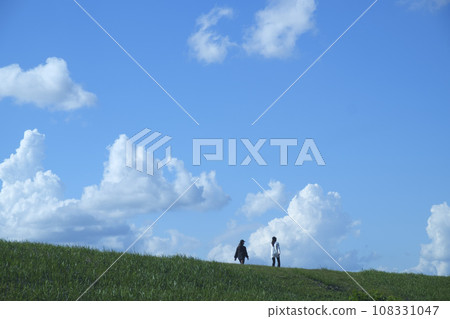 Walker walking on the hill with blue sky and clouds Walker walking on the hill with blue sky and clouds 108331047