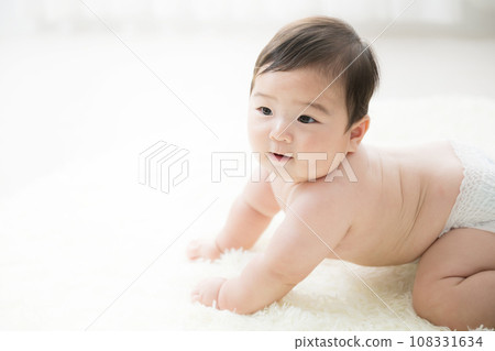 一個可愛、蓬鬆、赤裸上身的嬰兒,在背光下穿著尿布,有影印空間 一個可愛、蓬鬆、赤裸上身的嬰兒,在背光下穿著尿布,有影印空間 108331634