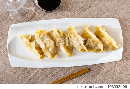 Steamed Yaki Gyoza served in a plate with sauce 108332406