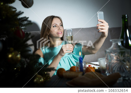 Woman taking selfie while celebrating Christmas 108332654