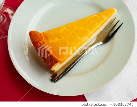 Piece of glazed cheesecake served in a plate 108332745