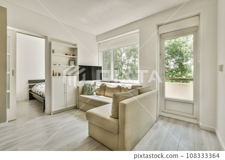 a living room with white walls and wood flooring the room is decorated in neutral tones, including light greys 108333364