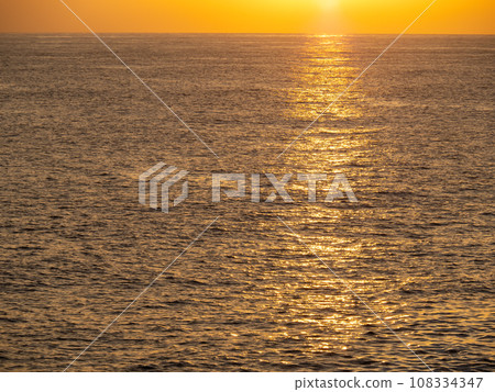 The calm summer sea surface (Pacific Ocean) colored by the sunset. From the coast of Muroto City, Kochi Prefecture in summer (August). 108334347