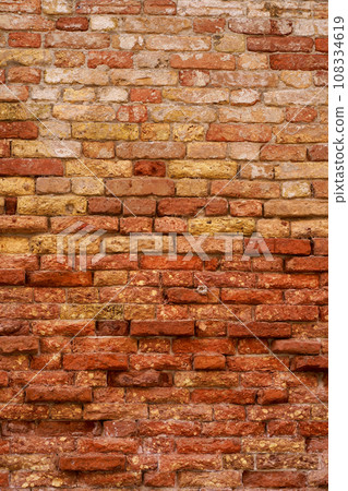 Texture of an old brick wall. Brick walls of Venice. Old red brick clay wall with on a sunny day. Clay brick walls of Italy. italian architecture and heritage Texture of an old brick wall. Brick walls of Venice. Old red brick clay wall with on a sunny day. Clay brick walls of Italy. italian architecture and heritage 108334619
