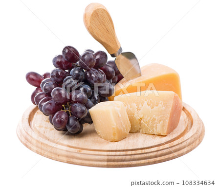 Parmesan cheese and ripe grapes on a wooden board on a white background Parmesan cheese and ripe grapes on a wooden board on a white background 108334634