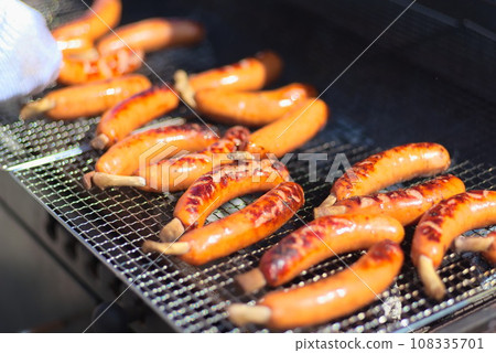 A large amount of frankfurters being baked on a wire mesh A large amount of frankfurters being baked on a wire mesh 108335701