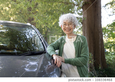 Senior woman smiling next to the car Senior woman smiling next to the car 108336468