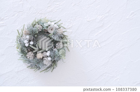 Christmas wreath on a white plaster wall Christmas wreath on a white plaster wall 108337380