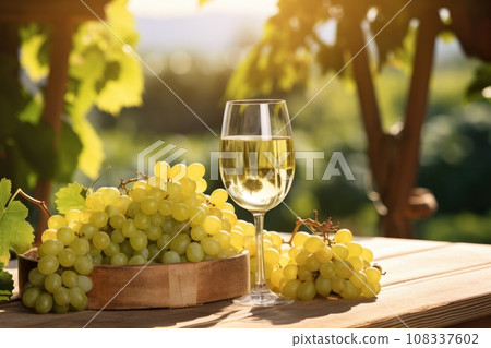 Glass of white wine with grapes on old wooden table 108337602