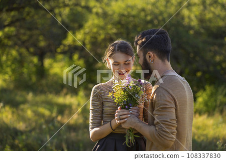 guy gives flowers to his girlfriend guy gives flowers to his girlfriend 108337830