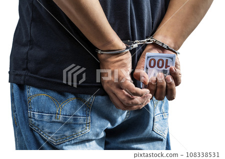 Arrested man with a handcuff on his hand holding money 108338531